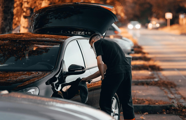 A picture of a person cleaning their car that has a vehicle protection plan from Veritas Global Protection