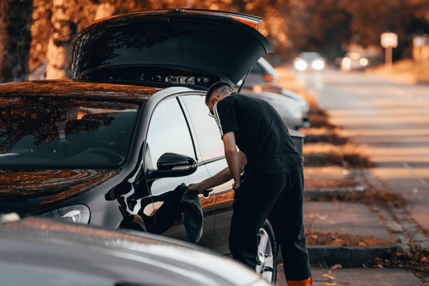 A picture of a person cleaning their car that has a vehicle protection plan from Veritas Global Protection